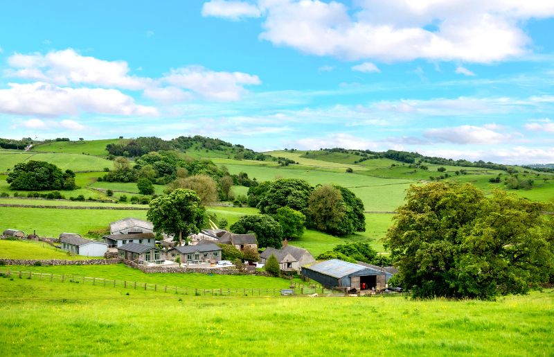 A view over a farm nestled in rolling Peak District hills